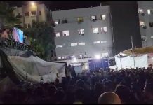 Palestinos se reúnen afuera del hospital Al-Shifa de Gaza para ver la proyección de imágenes de Hamás destruyendo vehículos militares israelíes
